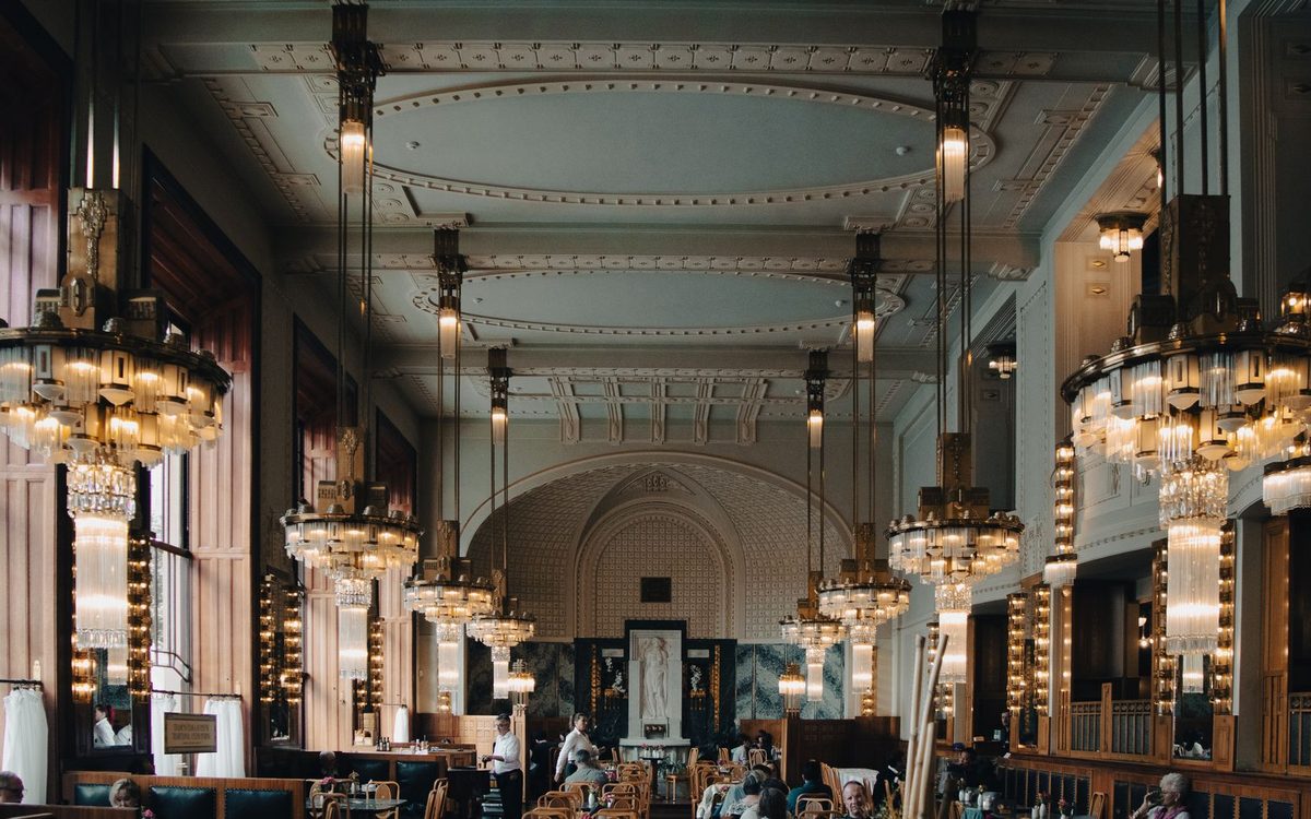Art Deco chandeliers and a long bar in a grand café interior