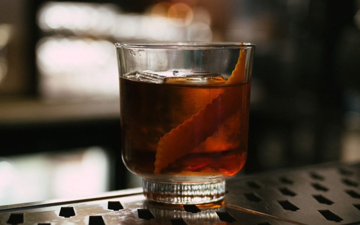 Cocktail glasses on a dark bar counter in warm light